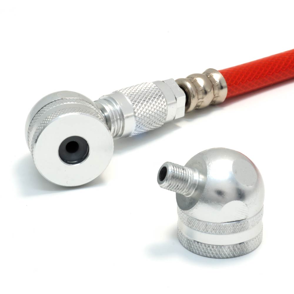 Close-up of a Prestacycle Big Angle Presta Head with a red pneumatic hose, metal connector, and urethane elastomer gasket, next to a separate silver fitting; both by Prestacycle for inflating tires or tubeless applications on white background.