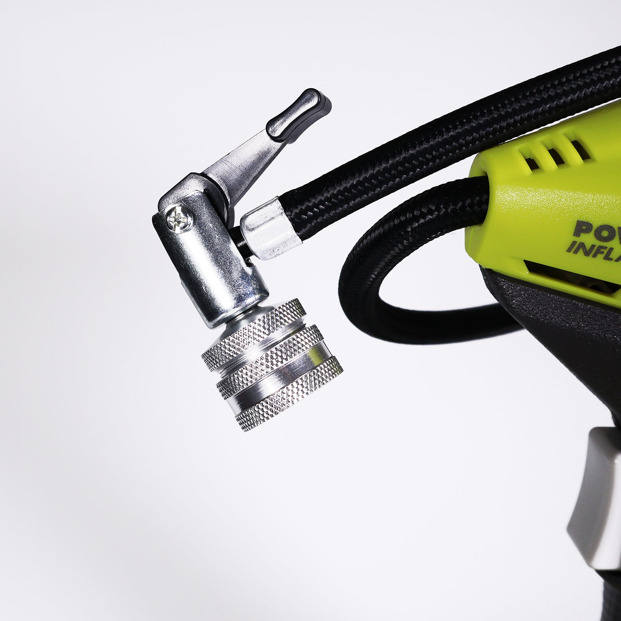 Close-up of a Prestacycle Big Presta Head air chuck attached to a black hose on a green portable inflator, set against a white background.