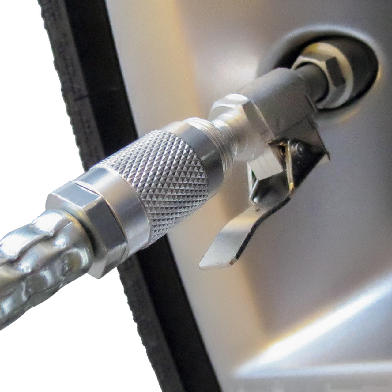 The Prestacycle Automotive Quick-Clip™ Schrader Head by Prestacycle is shown clipped to a car tire’s valve stem, inflating the tire. The metal nozzle features a textured grip and lever for a secure, easy connection.
