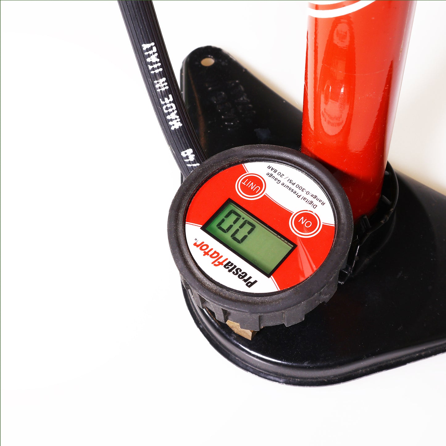 A close-up of the Prestacycle Prestaflator Digital Gauge for Air Compressors & Floor Pumps, showing “0.0” on its screen, attached to a red pump with a black hose and part of the black base visible.