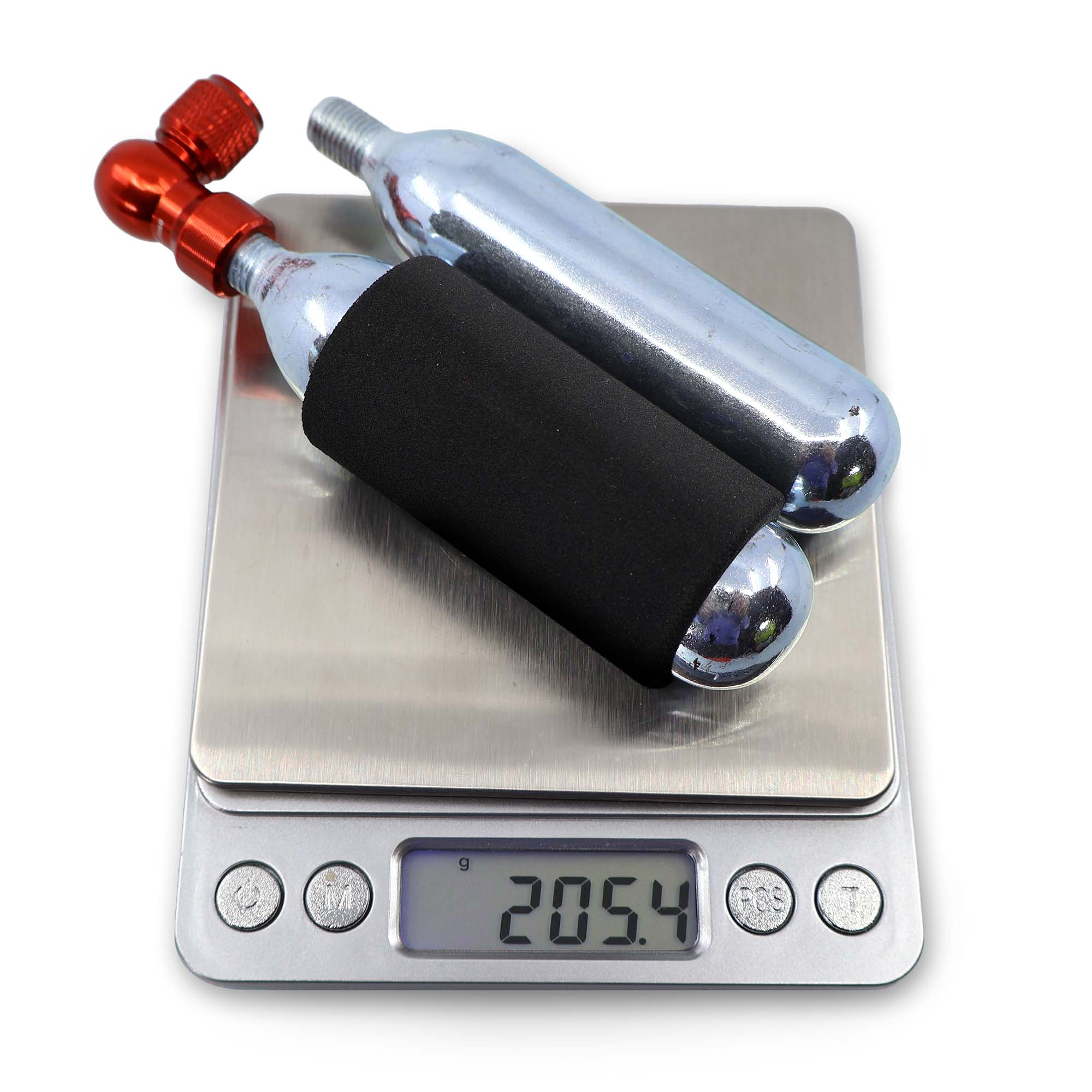 Two silver CO₂ cartridges—one with a black sleeve and red valve—sit on a digital scale reading 205.4g, ready for quick tire inflation with the Prestacycle Prestaflator GO Portable Digital Rechargeable Preset Bicycle Tire Inflator.