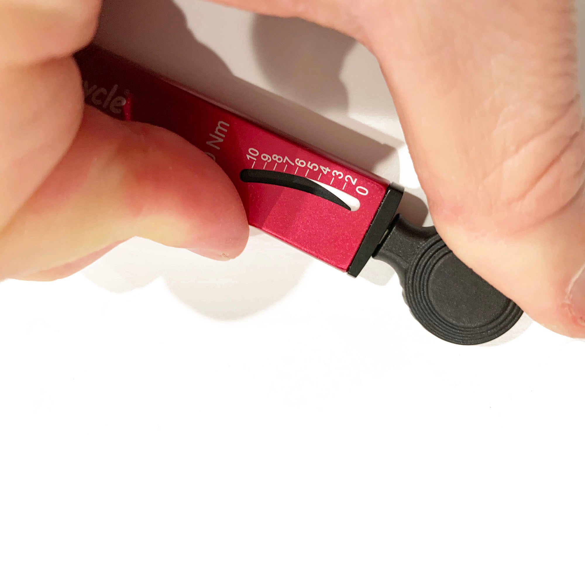 A hand adjusts the Prestacycle TorqRatchet PRO Deluxe, a Pro Pocket Multi-tool and 2–10Nm torque ratchet by Prestacycle, with its Newton meter scale visible against a white background.