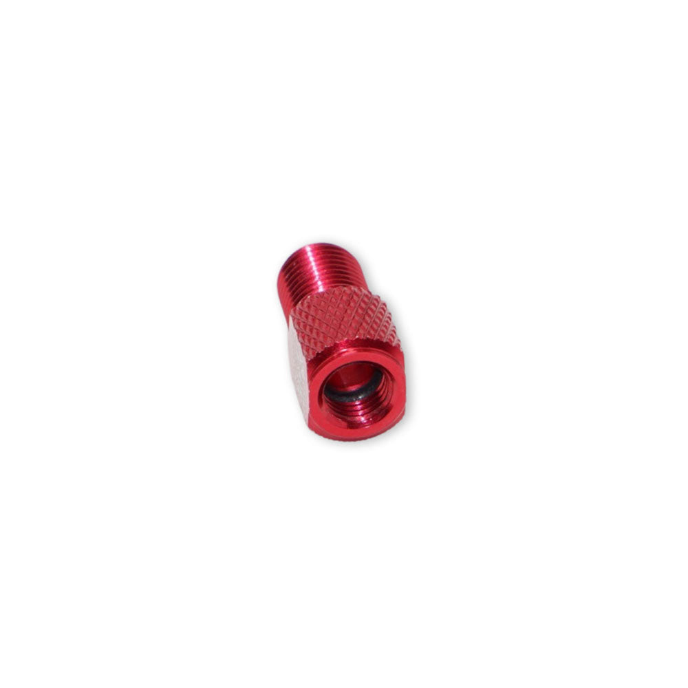 The Prestacycle Prestadapter TUBELESS is a small, red alloy Presta adapter and valve core remover with a textured grip and threaded ends, compatible as a Schrader to Presta valve adapter, shown on a plain white background.