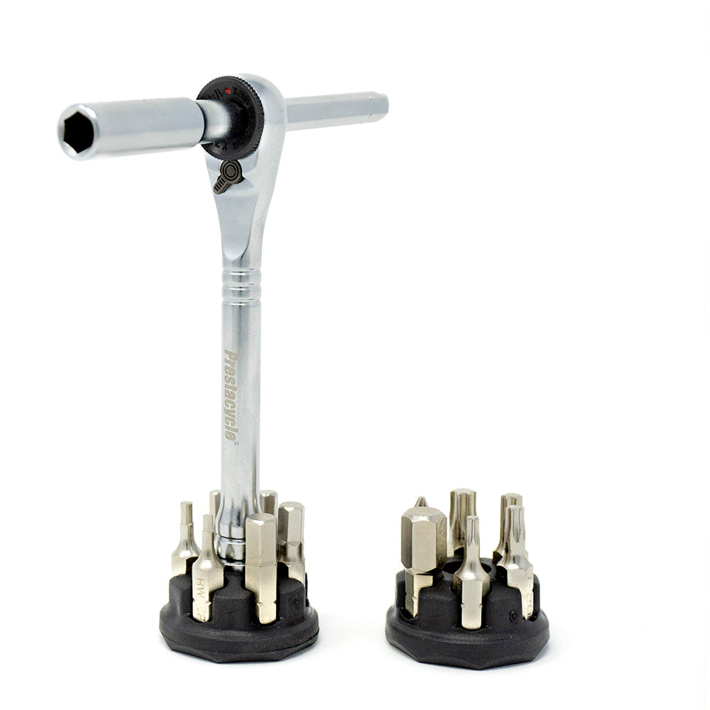 The Prestacycle Pro T-Handle Kit by Prestacycle stands upright, flanked by two circular holders filled with 1/4 inch bits and sockets, creating a compact desktop ratchet set displayed on a white background.