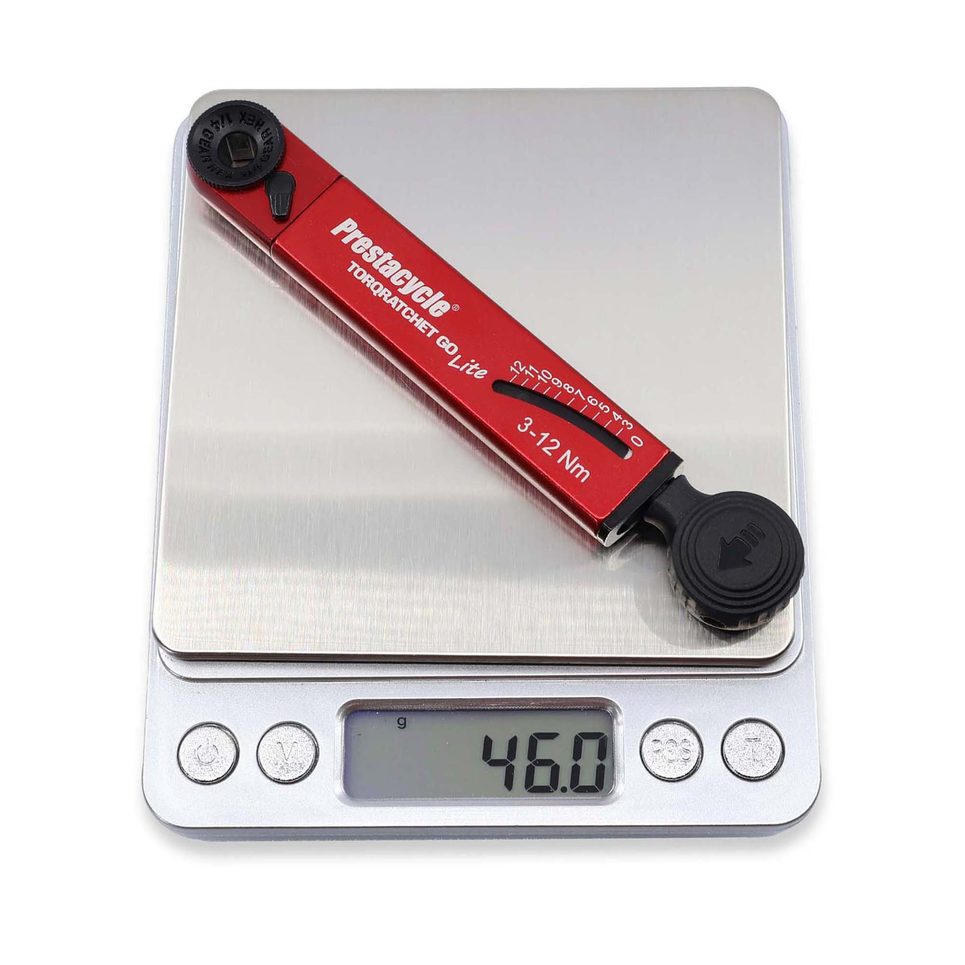 A red Prestacycle TorqRatchet GO Lite (3–12Nm), a portable multi-tool ratchet, rests on a digital kitchen scale showing 46.0 grams. The reversible ratchet feature allows for easy torque adjustments.