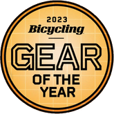 A round orange badge with a grid pattern, displaying 2023 Bicycling Gear of the Year in bold black and white—perfect for highlighting the Prestacycle UniBlock PRO Cassette (12 Speed) by Prestacycle, Shimano HG12 compatible.