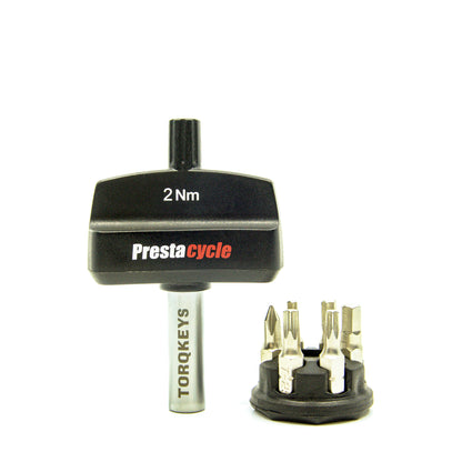 The Prestacycle Mini TorqKeys 2Nm Preset Torque Tool by Prestacycle features a black tool with a silver shaft, detachable head, and comes with a round holder containing 6 maintenance-free, nickel-plated S2 steel bits for precise work.