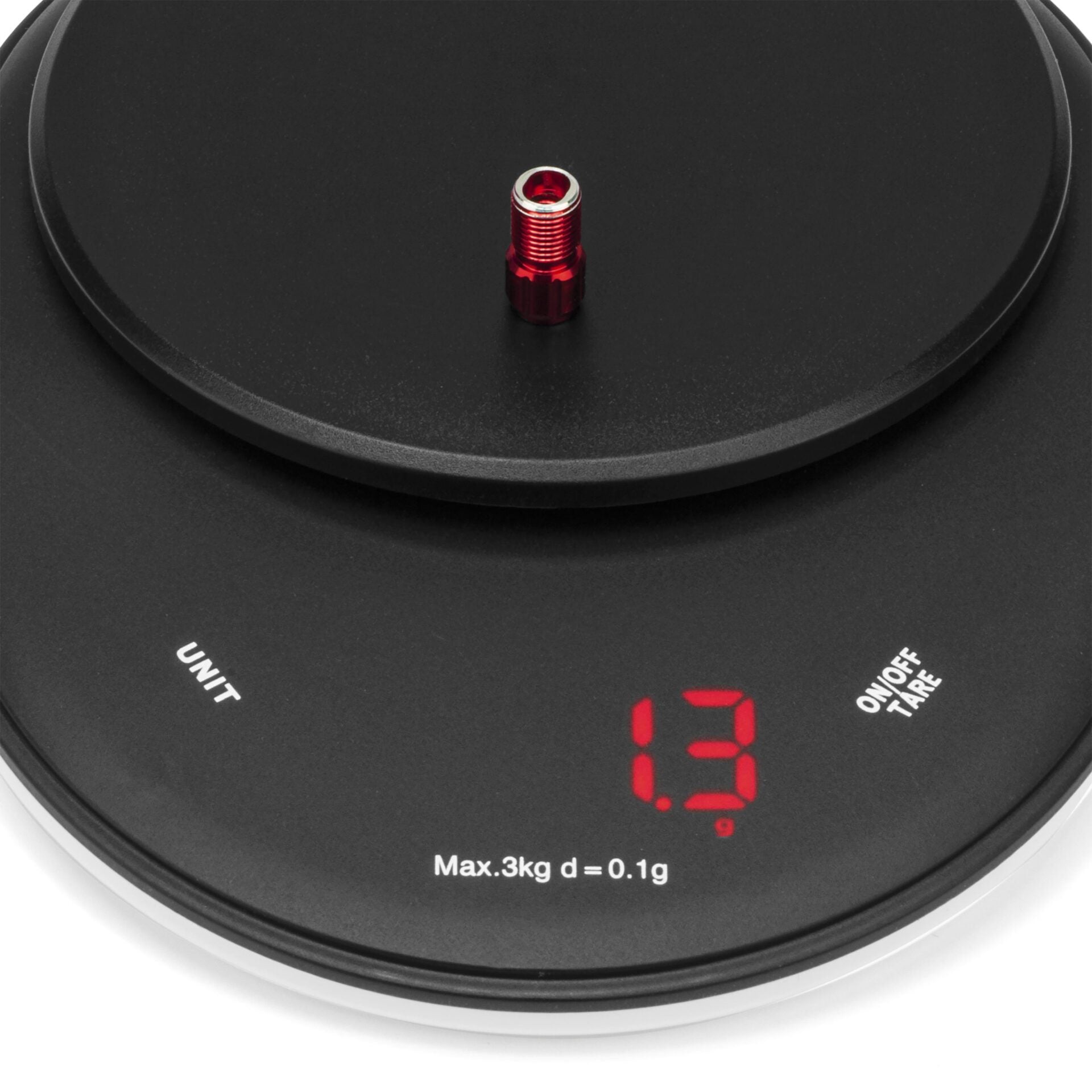 A black digital kitchen scale shows 1.3 grams in red digits as the Prestacycle Prestadapter—Schrader to Presta adapter and valve core tool by Prestacycle—sits at the center, with unit selection and on/off tare buttons visible.