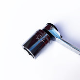 A close-up of the Prestacycle Professional Low-Profile 1/4 Hex to 1/4 Square Socket Adapter by Prestacycle, made from hardened S2 steel for durability, positioned diagonally on a white background.