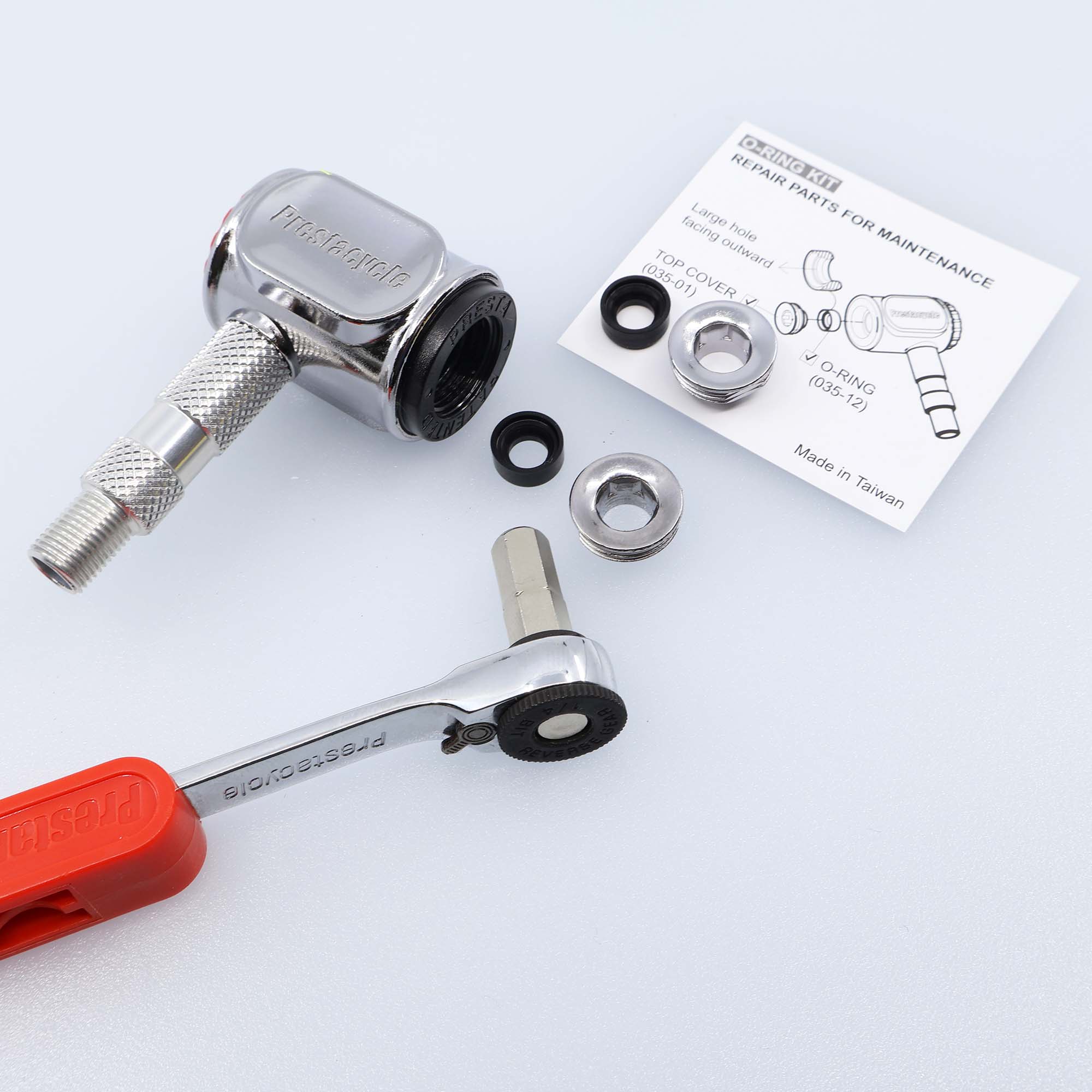 The Prestacycle Prestaflator Pro Presta Head Rebuild Kit, including a metal faucet cartridge, rubber washers, metal rings, a red-handled wrench, and an instruction sheet, is arranged on a white surface.