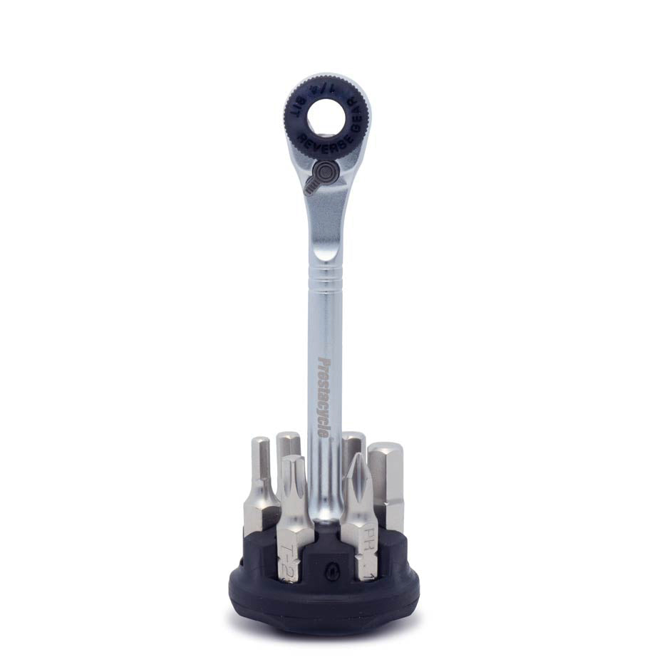 The Prestacycle Prestaratchet Micro – Kit with 6 S2 Bits is displayed upright on its round holder stand, surrounded by the interchangeable metal bits.