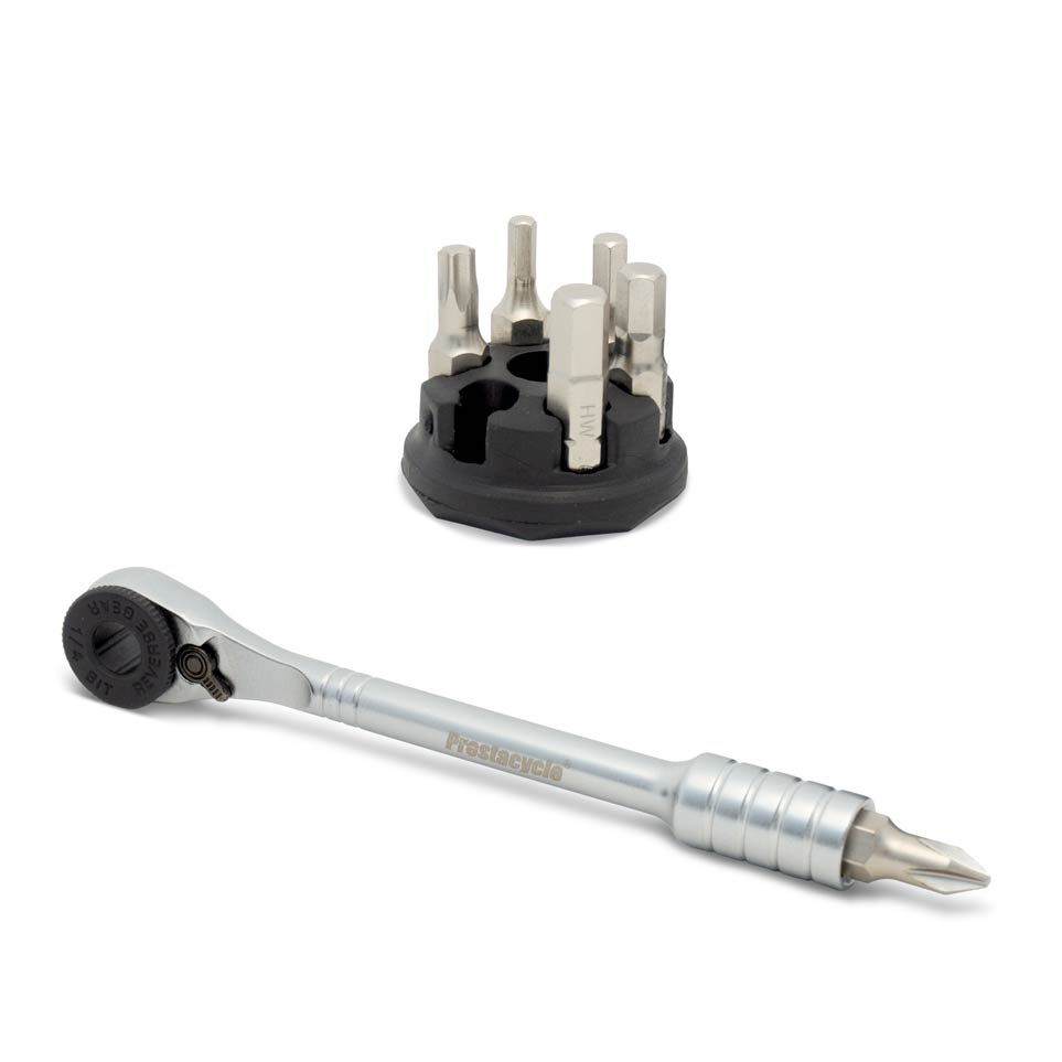 The Prestacycle Prestaratchet Micro kit features a metal reversible ratchet screwdriver with textured handle, detachable head, and a round holder stand containing 6 S2 bits—a compact, versatile tool for precise repairs.