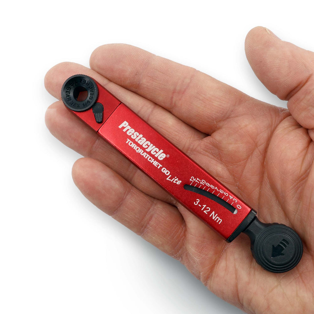 A hand holds a red Prestacycle TorqRatchet GO Lite, a portable 3~12Nm torque multi-tool ratchet, showcasing its adjustable settings and measurement scale.