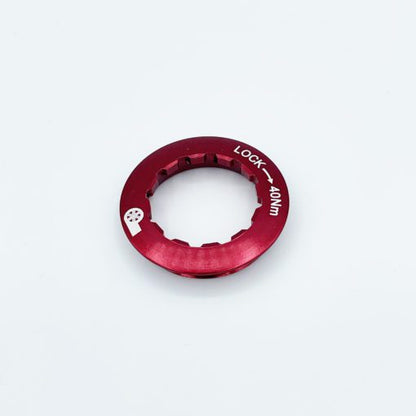 A red metal Prestacycle UniBlock PRO Cassette (12-Speed, Campagnolo, for HG11/HG10 Freehub) lockring with notched edges and LOCK – 40NM in white text is shown on a plain white background—ideal for securing your cassette.